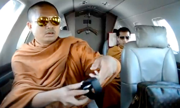 Corruption et scandales financiers : la crise de foi du bouddhisme thaïlandais 2 - thailande-fr Screengrab from YouTube of monk with aviator sunglasses, branded travel bag and wireless headphones