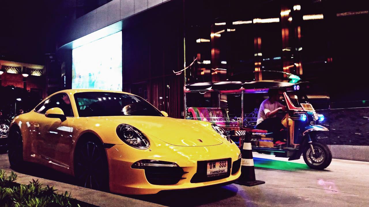Porsche et tuk-tuk devant un centre commercial à Bangkok